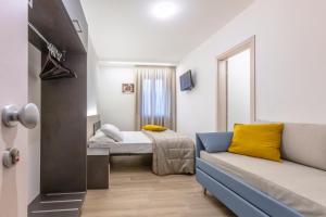 サン・マッシモにあるHotel Milettoのベッドとソファのある小さな部屋