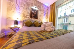 una camera da letto con un letto grande e una finestra di Leone Camere D'autore - CHIAIA a Napoli