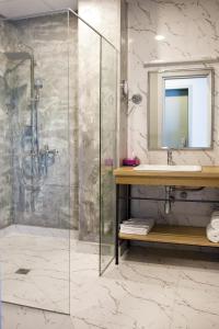a bathroom with a shower with a sink and a mirror at The Terrace Boutique Hotel in Tbilisi City