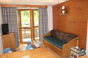a living room with a couch and a table at Les Chalets du Galibier II in Valloire