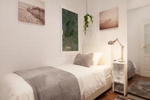 een witte slaapkamer met een bed en een lamp bij Rambla Poblenou&Mar Bella Beach in Barcelona