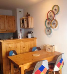 a wooden table in a kitchen with chairs around it at Les Chalets du Galibier II in Valloire