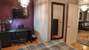 1 dormitorio con cama, escritorio y espejo en North London Apartment - Edmonton en Edmonton