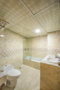 ein Badezimmer mit einem WC, einem Waschbecken und einer Badewanne in der Unterkunft Hotel Mira Garden in Sylhet