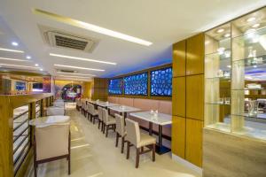 a restaurant with tables and chairs in a room at Hotel Mira Garden in Sylhet