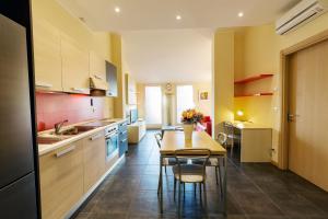 Residenza IL CASTELLO في سوندريو: مطبخ مع طاولة وكراسي في غرفة