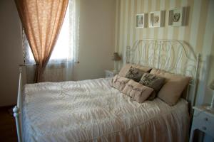 a bedroom with a white bed with pillows on it at Alle Falesie in Duino +7 photos