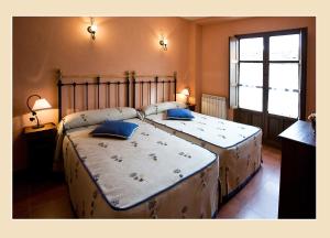 a bedroom with two beds with blue pillows on them at Casa Tia Paula in Carrión de los Condes
