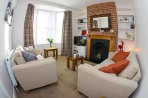 uma sala de estar com duas cadeiras e uma lareira em 15 Saxon Road em Exeter