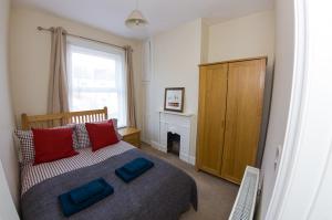 a bedroom with a bed with two blue pillows on it at 15 Saxon Road in Exeter