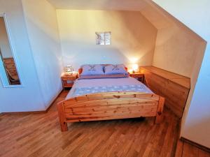 a bedroom with a wooden bed with two night stands at Apartment Alpine Lake in Bled