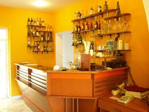 a yellow room with a counter and shelves with bottles at Hotel Mures in Topliţa