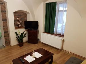 ein Wohnzimmer mit einem Tisch und einem grünen Vorhang in der Unterkunft Central am Brukenthal in Sibiu