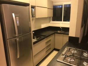 a kitchen with a stainless steel refrigerator and a stove at Ocean Life in Florianópolis