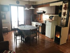 a kitchen with a table and a kitchen with a refrigerator at Villaggio Bianco in San Giacomo