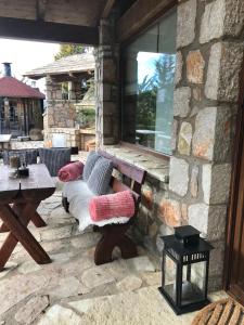 een stenen patio met een bank en een tafel bij villa in Parnassos in Arachova