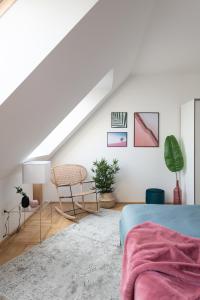 ブダペストにあるGozsdu Design Apartmentの白い屋根裏のベッドルーム(ベッド1台、椅子付)