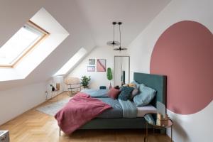 ブダペストにあるGozsdu Design Apartmentのピンクの壁、ベッド1台付きのベッドルーム1室