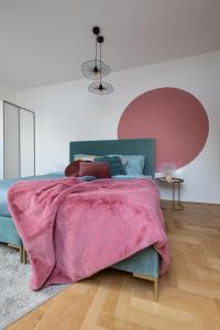 ブダペストにあるGozsdu Design Apartmentのベッドルーム1室(ピンクの毛布付きのベッド1台付)