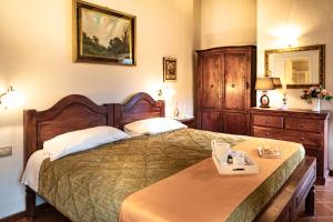 a bedroom with a large bed with a wooden headboard at Parco delle Nazioni - Relax Grand Resort in Castel di Decima