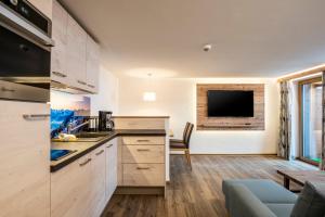 una cucina con armadi in legno e una TV a parete di Haus am Rank a Oberstdorf