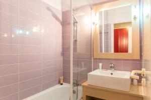 a bathroom with a sink and a tub and a mirror at Village Pierre & Vacances Moliets in Moliets-et-Maa