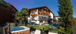 a house with a swimming pool and a hot tub at Hotel Alpenhof in Tirolo