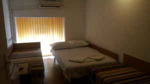 a small bedroom with two beds and a window at Hostel Ruschuk in Ruse