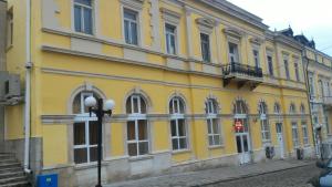 a yellow building on the side of a street at Hostel Ruschuk in Ruse