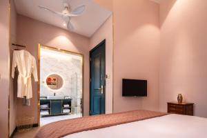 a bedroom with a bed and a mirror and a sink at Moon and Chalice Boutique Hotel in Kunming