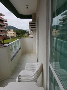 - Balcón con sillas blancas en un edificio en Residencial Júnior, en Bombinhas