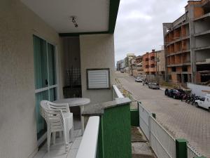 Un balcón con una mesa y sillas y una calle. en Residencial Júnior, en Bombinhas