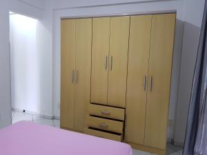 1 dormitorio con armarios de madera y 1 cama en Residencial Júnior, en Bombinhas