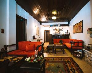 a living room with orange couches and a fireplace at Evilion Traditional Inn in Plakotón