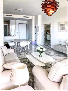 a living room with white furniture and a table at Sunset Drive by Albamar in Benidorm