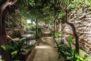 Un jardín con mesas, sillas y árboles. en Médousa Bistrot & Suites, en Taormina