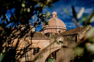 un bâtiment avec une tour en haut dans l'établissement Le Cupole Suites & Apartments, à Trapani