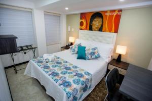a bedroom with a bed and a painting on the wall at Hotel San Blass Boutique in Pasto