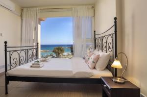 Schlafzimmer mit einem Bett und Meerblick in der Unterkunft Protaras Fig Tree Bay Suite in Protaras