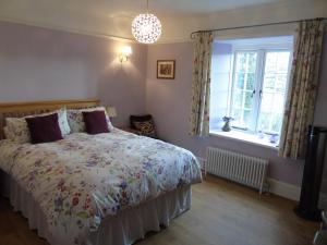 1 dormitorio con cama y ventana en Spillers Farm en Axminster