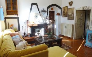 a living room with a yellow couch and a fireplace at La Celestina in Piana Crixia