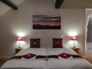 1 dormitorio con 1 cama blanca grande con almohadas rojas en Pyrenées Emotions, en Malvézie