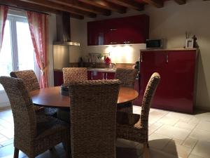 a dining room with a table and chairs and a kitchen at Le Gîte de Marie in Ludes