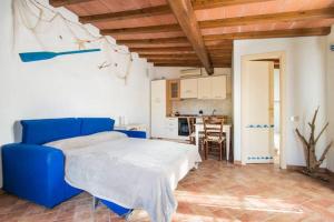 a bedroom with a blue bed and a kitchen at ❤Il Piccolo Nido...Romantico monolocale di Design❤ in Marina di Pietrasanta