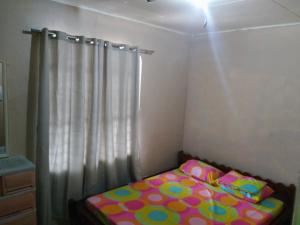 uma pequena cama num quarto com uma cortina em Fleetwood Suites em Santo Tomas