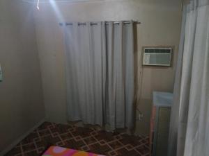 a bathroom with a shower with a shower curtain at Fleetwood Suites in Santo Tomas