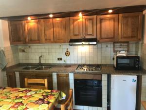 ロッカラーゾにあるResidenza MareaCasaのキッチン(木製キャビネット、シンク、コンロ付)