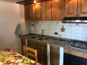 ロッカラーゾにあるResidenza MareaCasaのキッチン(木製キャビネット、シンク、テーブル付)