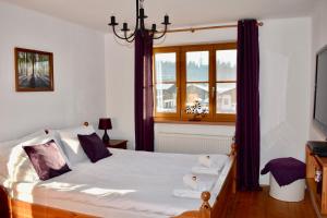 a bedroom with a large bed with purple curtains at Haus Thomas in Werfenweng