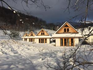 un groupe de maisons dans la neige dans l'établissement Chaty pod Beskidkiem, à Szczyrk